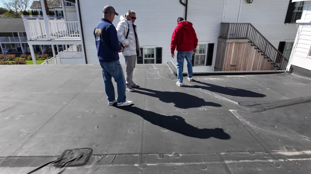 Denis and customers discussing roofing details