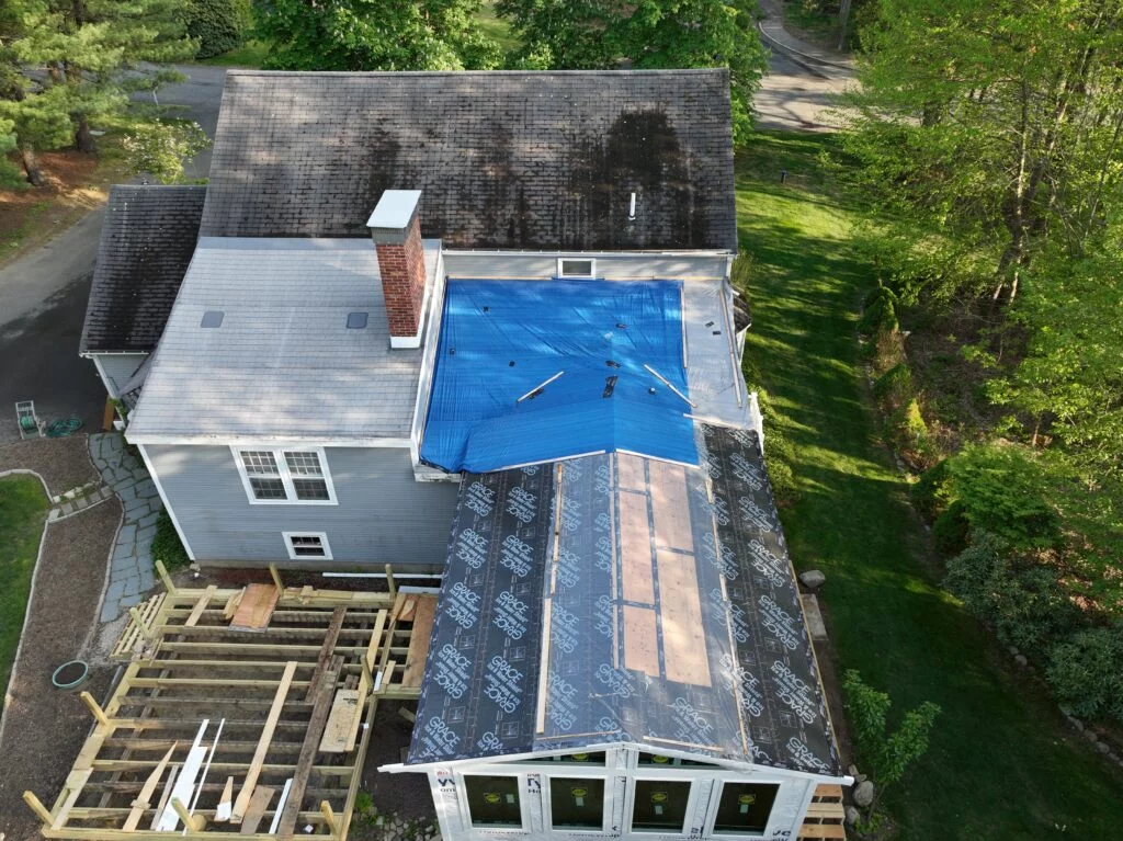 House under renovation with a blue tarp on the roof