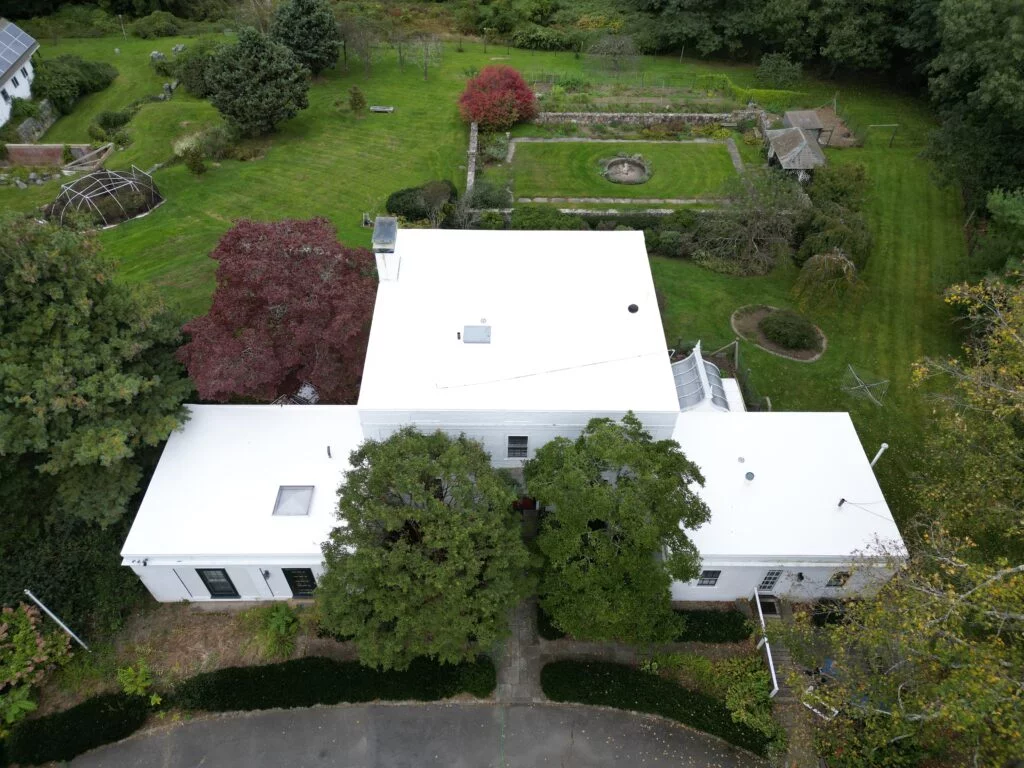 Aerial view of a castle-like home featuring a newly installed PVC roof