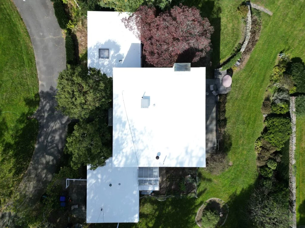Aerial view of the white flat roof installation at 224 Adams St Milton, showing the layout of the property and surrounding greenery