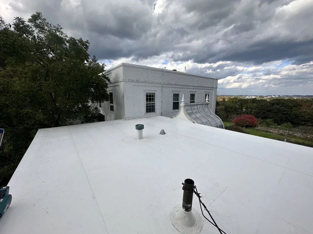 Newly installed white PVC flat roof at 224 Adams St Milton, featuring a view of the property and surrounding landscape